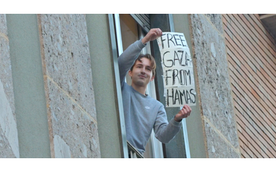 Corteo per la Palestina, giovane provoca i manifestanti: si affaccia dal balcone col cartello “Free Gaza from Hamas” – Video