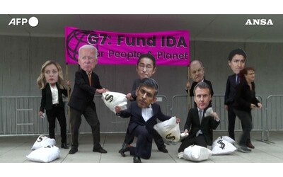 manifestanti con maschere dei leader de g7 a washington la protesta per chiedere fondi per l associazione per lo sviluppo