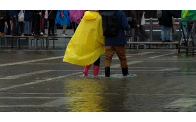 pioggia a venezia torna l acqua alta nel capoluogo veneto e i turisti camminano sulle passerelle le immagini