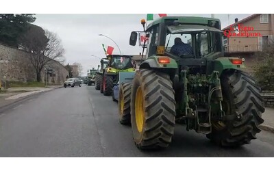 protesta degli agricoltori i trattori in marcia verso roma tra bandierine italiane e inno e il sindaco di vetralla li accoglie con la fascia tricolore