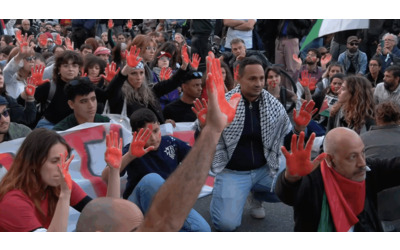 Flotilla, flash-mob a Milano: manifestanti con mani e volti dipinti di rosso in piazzale Loreto
