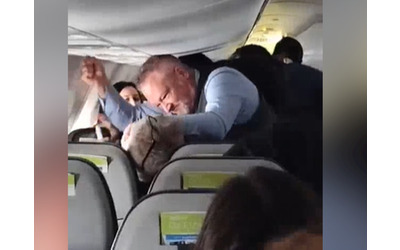 Passeggero prende per i capelli una donna sull’aereo: l’assistente di volo interviene e lo prende a pugni. Il video choc